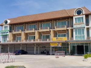 a hotel with a parking lot in front of it at Crystal Place Buayai in Bua Yai