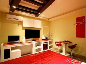 sala de estar con TV y alfombra roja en Asan ING Hotel en Asan