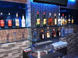 a bar with a bunch of bottles of alcohol at Zanrock Micro Hotel in Lagao III