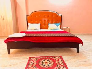 a bed with an orange headboard and a red blanket at Bharat Vandana Stay near Yashobhoomi in New Delhi