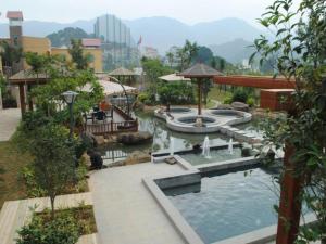 ein Schwimmbad in einem Park mit einem Brunnen in der Unterkunft Fuzhou Chuanjie Hotspring and Golf Club Hotel in Guling