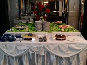 une table avec des assiettes de nourriture au-dessus dans l'établissement Couleur Hotel Cengkareng, à Jakarta
