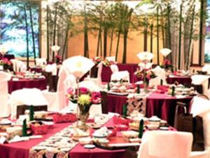 un comedor con mesas púrpuras y sillas blancas en Miyakonojo Royal Hotel, en Miyakonojō