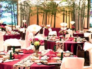een eetkamer met paarse tafels en witte stoelen bij Miyakonojo Royal Hotel in Miyakonojo