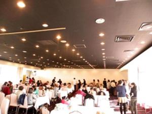 een menigte mensen in een kamer met stoelen bij Miyakonojo Royal Hotel in Miyakonojo