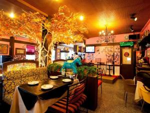 un restaurante con mesa, sillas y un árbol en Numsin Hotel, en Ban Rong Chang