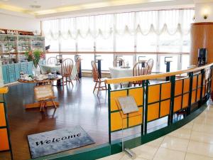 亀ノ浦にあるTara Kanko Hotelのテーブルと椅子、ウェルカムサイン付きのレストランを併設しています。