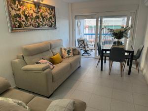 sala de estar con sofá y mesa en Apartamento Muchavista Primera Línea de Playa By El Conserje en El Campello
