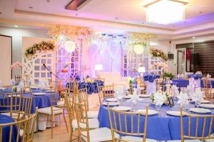 ジェネラル・サントスにあるAnchor Hotelの青いテーブルと椅子が備わる宴会場