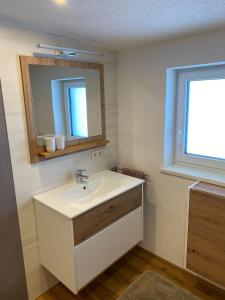 baño con lavabo, espejo y ventana en Apartment Auszeit, en Brandberg