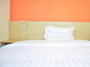 a bedroom with a bed with an orange wall at 7 Days Premium Rizhao Ju County Ancient City in Rizhao