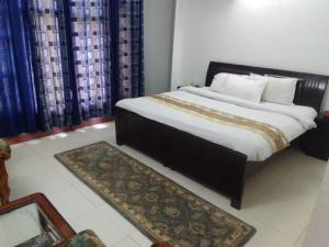 a bedroom with a large bed and a rug at Mashoo Resorts , Bhuntar in Shamshi