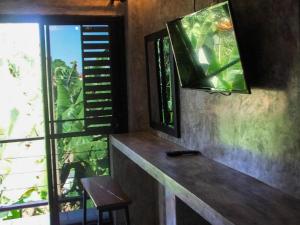 Habitación con TV, silla y ventana. en SabayNan Hotel en Ban Nong Tao