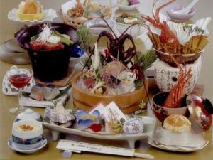 una mesa con muchos platos de comida. en Tomoyama Kanko Hotel en Azena