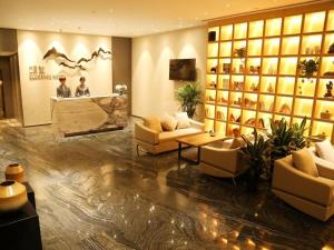 a lobby of a hotel with couches and a counter at Qingdao Elegance Hotel in Qingdao
