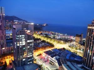 a view of a city at night with lights at Qingdao Elegance Hotel in Qingdao