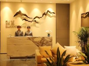 two men sitting at a counter in a lobby at Qingdao Elegance Hotel in Qingdao