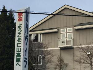 una casa con un cartel delante de ella en Niyama Onsen Hotel NK Vila, en Tōgenoshita