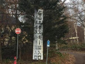 Znak z azjatyckim napisem obok znaku stopu w obiekcie Niyama Onsen Hotel NK Vila w mieście Tōgenoshita