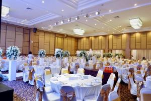 um grande salão de banquetes com mesas e cadeiras brancas em The Impress Nan Hotel em Nan