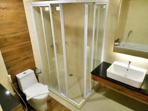 een badkamer met een douche, een toilet en een wastafel bij Mayflower Grande Hotel in Hat Yai