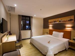 a hotel room with a bed and a television at 7 Days Inn Yingshang Lanxing Building Materials Market in Fuyang