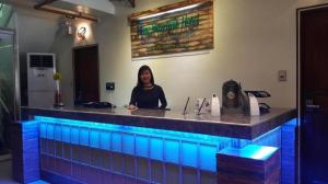 a woman sitting at a bar with blue lights at Time Travellers Hotel in Manila