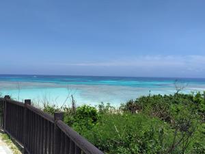 a view of the ocean from a wooden fence at やどバンブー in Hateruma