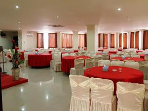un salón de banquetes con mesas y sillas rojas y blancas en Smart Hotel, en Lubuklinggau