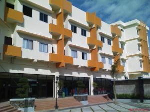 un edificio de color naranja y blanco en Smart Hotel, en Lubuklinggau