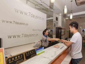 een man en een vrouw die eten kopen aan de balie bij 7 Days Inn Weinan Dongfeng Street in Weinan