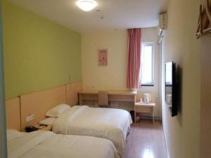 een hotelkamer met 2 bedden en een televisie bij 7 Days Inn Weinan Dongfeng Street in Weinan