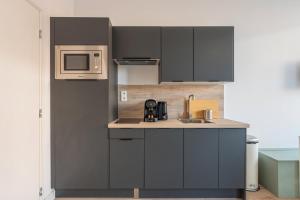 トゥールコワンにある1 bedroom apartment in city center with parkingの小さなキッチン(黒いキャビネット、電子レンジ付)