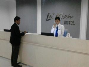Dwóch mężczyzn stoi przy recepcji. w obiekcie Le Man Hotel Lampung w mieście Umbulan Tulungmeris