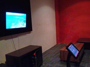 Pokój z telewizorem i stołem z tabletem w obiekcie Le Man Hotel Lampung w mieście Umbulan Tulungmeris