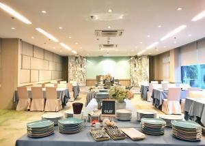 un salón de banquetes con mesas azules, sillas y platos en Clef Hotel Bangkok, en Ban Khlong Samrong