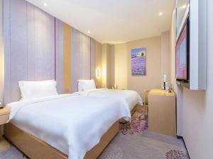 a hotel room with two beds and a television at Beijing Lavande Hotel Shunyi Subway Station Branch in Shunyi