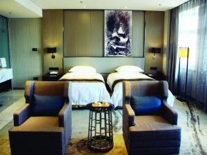 Shuangcheng的住宿－Harbin Splendent Hotel，一间卧室配有一张带两把椅子和一张桌子的床。