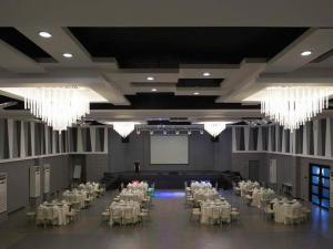 un gran salón de banquetes con mesas blancas y lámparas de araña en Isabela Zen Hotel & Restaurant Corporation, en Santiago