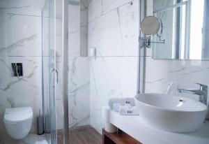 a white bathroom with a sink and a toilet at H41 Luxury Suites in Belgrade