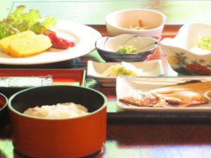 una mesa con platos de comida y tazones de comida en Otaiko Hills en Kami-itofu