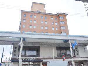 Mizusawa Grand Hotel في Oshu: مبنى كبير أمامه جسر