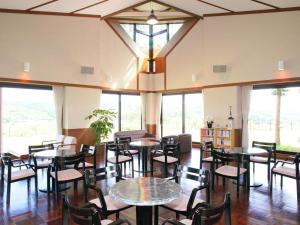 Tategamori Kogen Hotel في إتشينوسيكي: مطعم بطاولات وكراسي ونوافذ