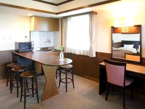 Tategamori Kogen Hotel في إتشينوسيكي: مطبخ مع طاولة وكراسي وسرير