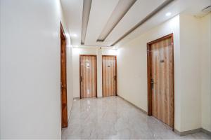 an empty room with two doors and a tile floor at FabHotel ADA Residency in Noida