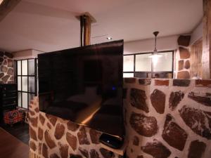 a living room with a stone wall with a flat screen tv at Gallery Hotel in Daegu