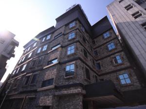 a tall brick building with windows at Gallery Hotel in Daegu