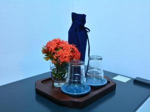 a tray with a vase of flowers and glasses on a table at The Indigo House Phrae in Phrae +47 photos