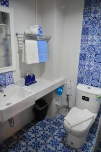 niebiesko-biała łazienka z toaletą i umywalką w obiekcie The Indigo House Phrae w mieście Ban Rong Fong