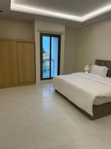 a bedroom with a large bed and a large window at شقة فاخرة مودرن in Al Kharj